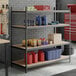 A black heavy-duty steel upright shelving unit with multiple shelves holding various garage and workshop supplies.