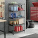 A black metal five-shelf boltless wire shelving unit with various garage supplies stored on it.