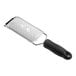 A metal ribbon grater with a black handle and a rectangular grating surface.
