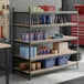 A black heavy-duty 5-shelf boltless particle board shelving unit with 72-inch uprights, used for organized storage in a garage or workshop.