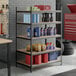 A black heavy-duty five-shelf boltless particle board shelving unit with 72-inch uprights, used for organized storage in a garage or workshop.