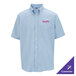 A men's light blue short sleeve oxford dress shirt with a button-down collar, front pocket, and customizable logo on the chest.