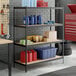 A black Z-beam 4-shelf boltless particle board shelving unit with 72-inch uprights, used for storage in a garage or workshop setting.
