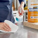A person cleaning a counter with a Lavex Just Enough 2-Ply paper towel.