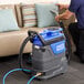 A man using a Lavex heated spot extractor to clean a couch.