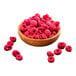 Freeze-dried whole raspberries in a wooden bowl.