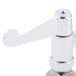 A close-up of a chrome Equip by T&S deck-mounted faucet with wrist handles.