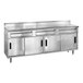 A stainless steel kitchen cabinet with three drawers on a stainless steel kitchen counter.