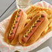 A Hebrew National beef hot dog with mustard in a bun on a paper tray with fries.