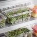 A group of Inline Plastics Safe-T-Fresh clear plastic containers filled with salads and fruit.