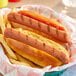 A basket of Hebrew National beef hot dogs and fries on a table in a stadium concession stand.