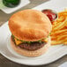 A cheeseburger on a plate with an OMG...It's Gluten Free hamburger bun.