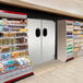 An Aleco Fieldstone Gray single swinging door with a window in a store with shelves of food.