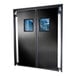 A black rigid double swinging traffic door with square windows.