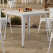 A Lancaster Table & Seating outdoor table with white legs.