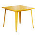 A Lancaster Table & Seating citrine yellow table with metal legs and a square top.