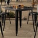 A Lancaster Table & Seating black metal table with black metal legs.