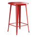 A Lancaster Table & Seating ruby red metal table with a metal base and white edges.