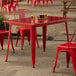 A red table and chairs on a patio.