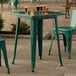 A Lancaster Table & Seating emerald green table with glasses of beer on it.