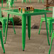 A Lancaster Table & Seating jade green table and chairs on a patio.
