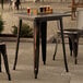 A Lancaster Table & Seating distressed copper outdoor table with drinks on it.