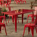 A red table and chairs on an outdoor patio.