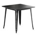 A Lancaster Table & Seating black metal square table with legs.