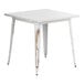 A Lancaster Table & Seating white metal square table with distressed legs.