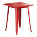 A red Lancaster Table & Seating outdoor table with legs.