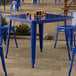 A Lancaster Table & Seating blue quartz table on an outdoor patio with glasses of beer on it.