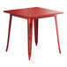 A Lancaster Table & Seating distressed ruby red metal table with legs.