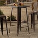 A Lancaster Table & Seating copper bar height table on an outdoor patio.