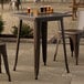 A Lancaster Table & Seating outdoor table with drinks on it.