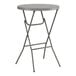 A round gray bar height folding table with metal legs.