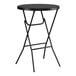A round black bar height folding table with black metal legs.