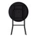 A round black heavy-duty plastic folding table with black legs shown in a folded position.