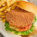 A Rebellyous spicy plant-based chicken patty on a plate with fries.