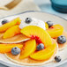 A plate of pancakes topped with Simplot Simple Goodness IQF sliced peaches and cream.