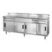A stainless steel Advance Tabco work table with 2 drawers and 4 sliding doors.