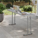 A gray heavy-duty blow molded plastic folding table with gray legs, set up outdoors with drinks and snacks on top.