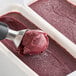 A scoop of red Sambazon Organic Acai in a container.