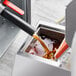A Shortening Shuttle BOSS machine pouring liquid into a container.