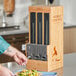 A man using a World Centric touchless cutlery dispenser on a counter.