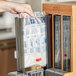 A hand holding a World Centric TPLA fork refill sleeve