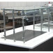 A stainless steel and glass self service food shield on a glass bakery counter.