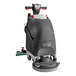 A NaceCare TGB 817NX walk behind floor scrubber with a red handle and black wheels on a white background.