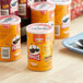 A table with a group of Pringles Cheddar Cheese potato chip containers.