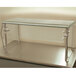 An Advance Tabco single tier self service food shield with metal legs on a counter.