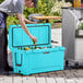 A man putting beer into a blue CaterGator outdoor cooler.